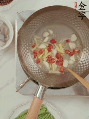 油7成熱時(shí)，下大蒜粒、姜絲、小米辣煸香。